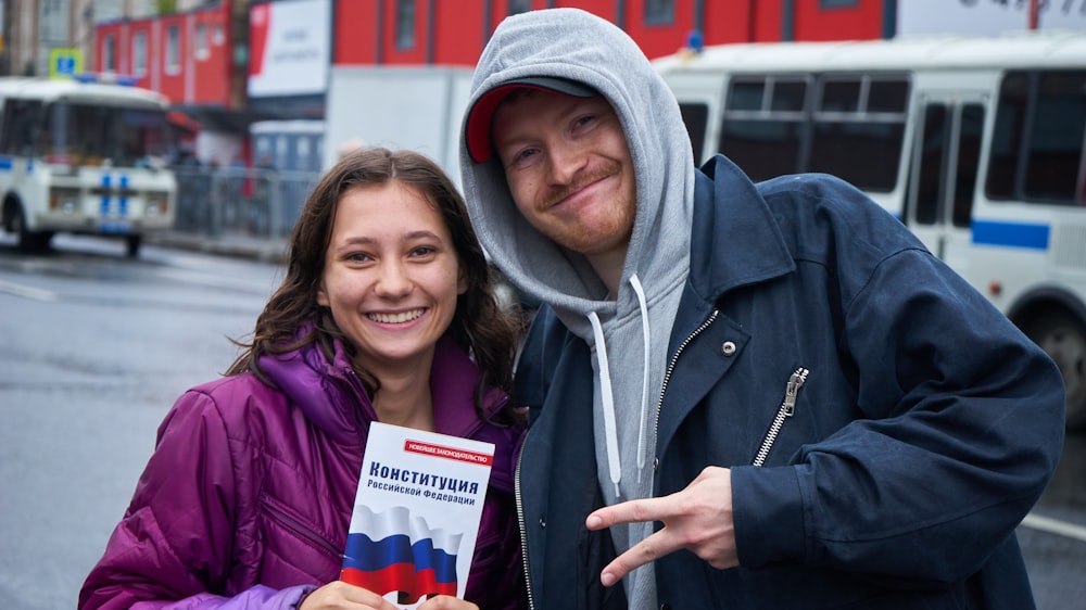 man in gray hoodie beside woman in purple jacket