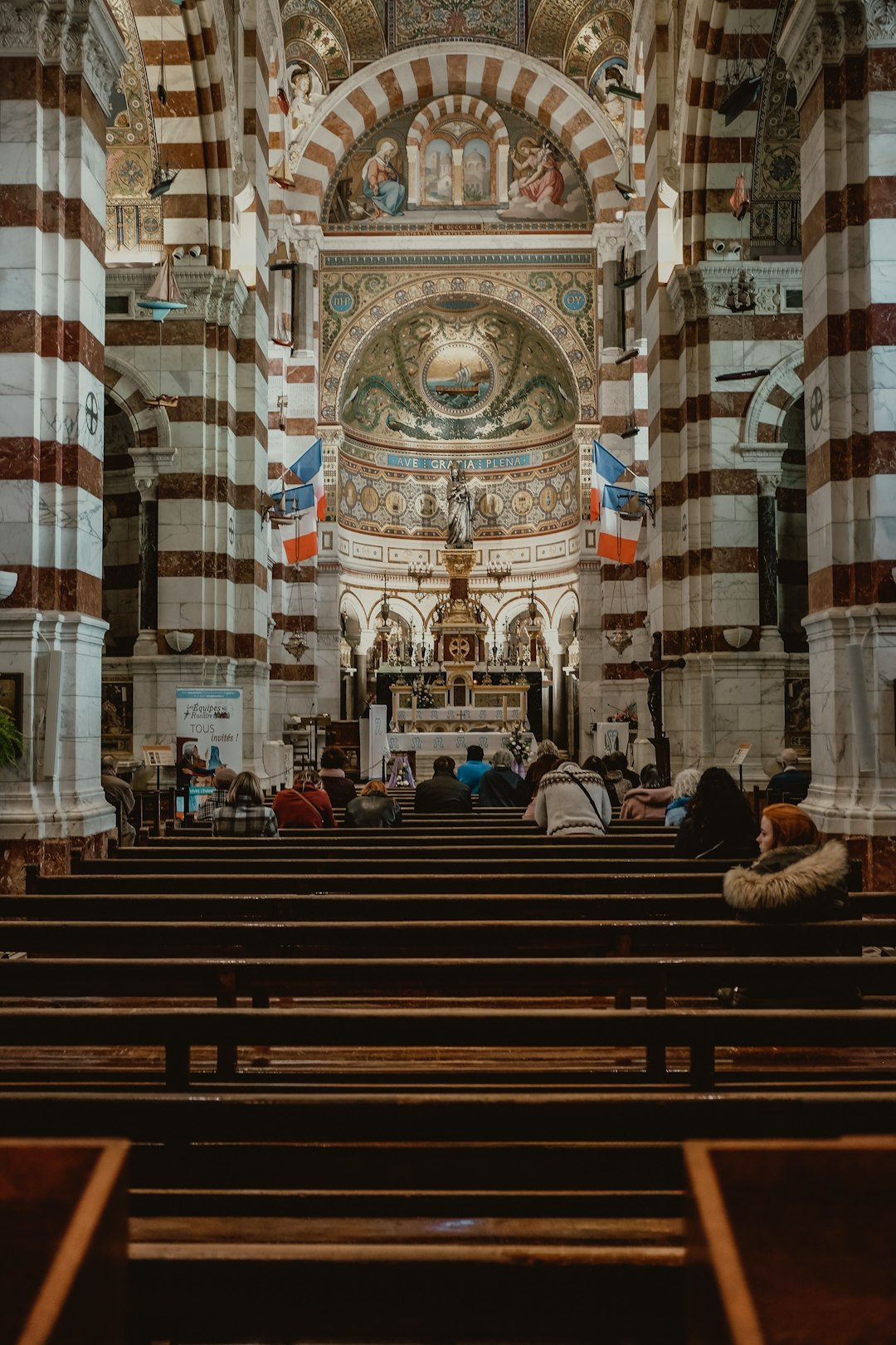 people sitting on brown wooden bench inside church