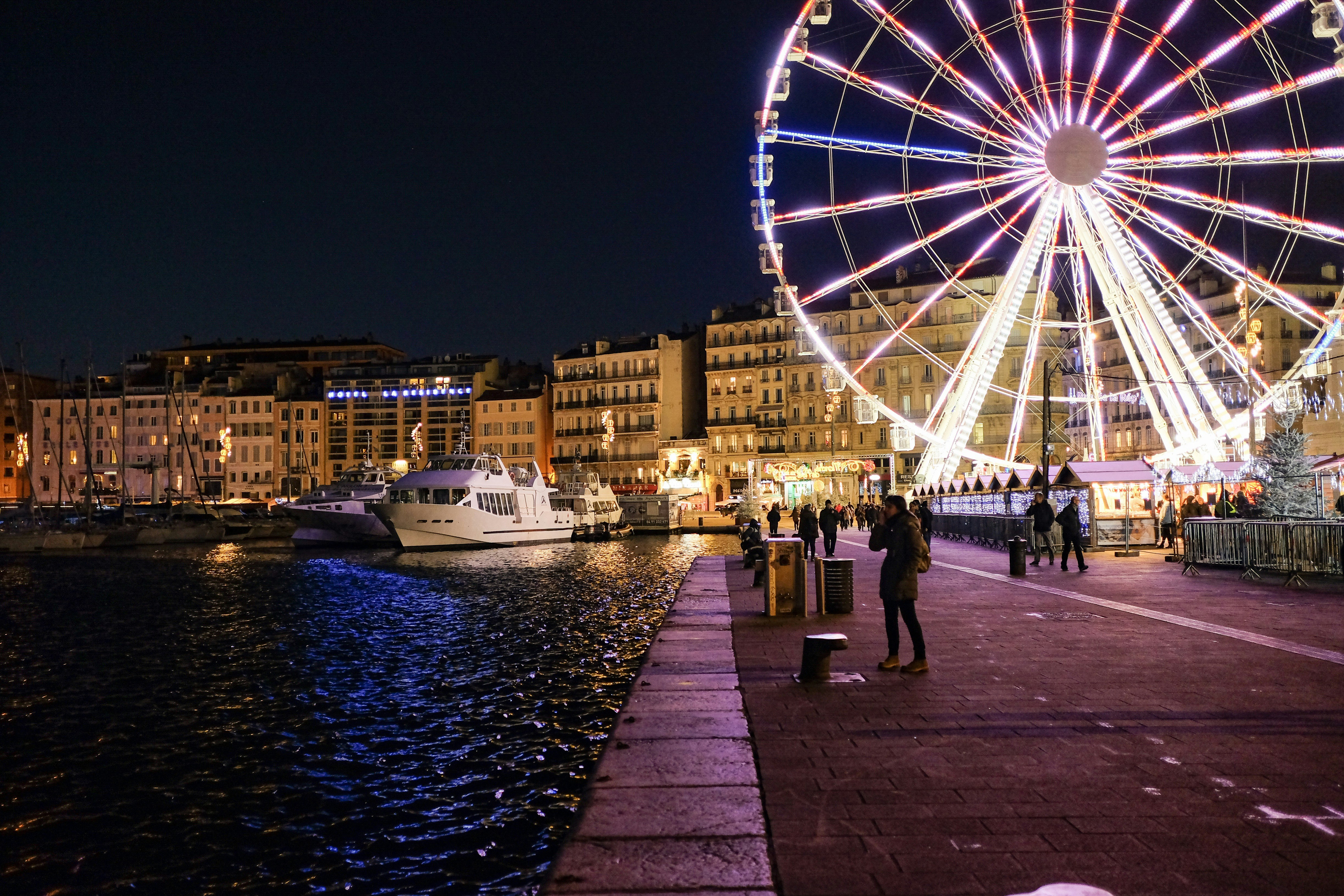 people walking on sidewalk near ferris wheel during night time, 