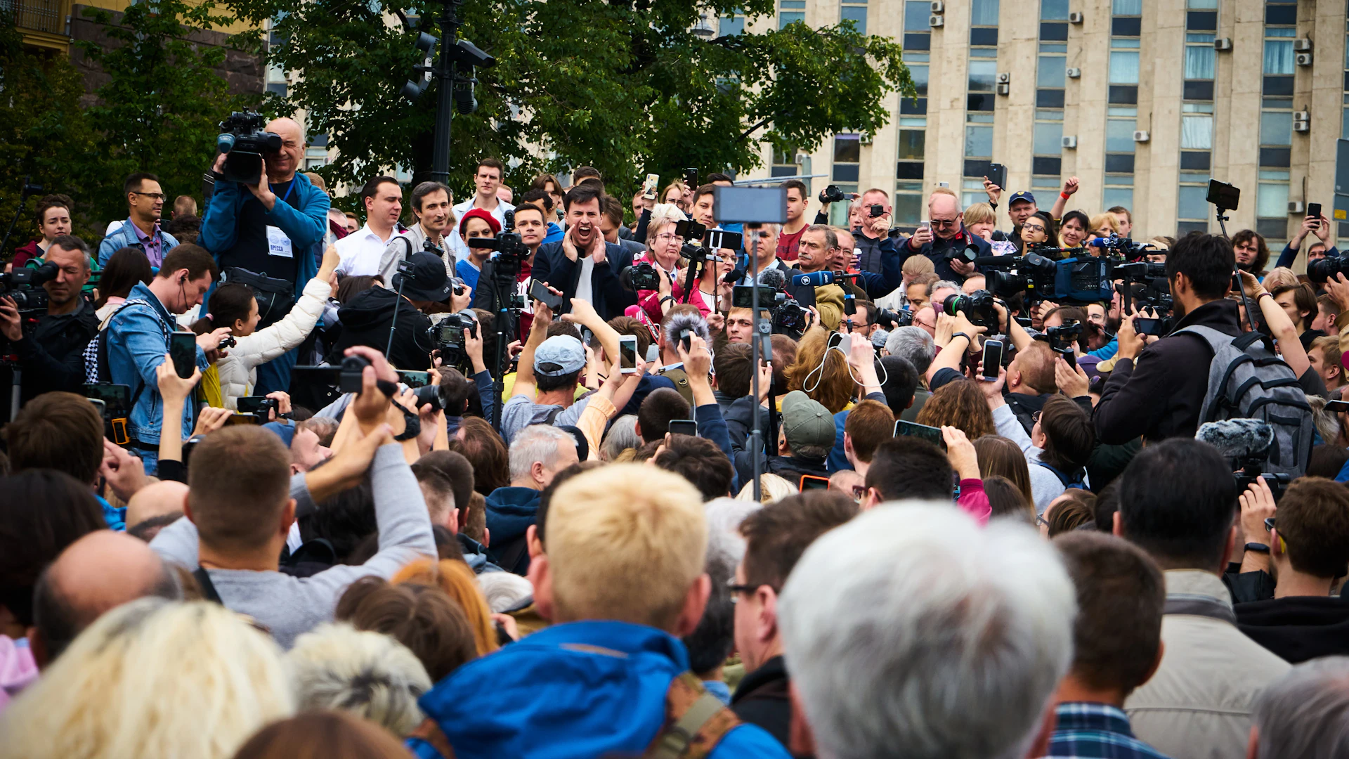 A vibrant snapshot capturing a breaking news moment with reporters in action and flashing cameras.