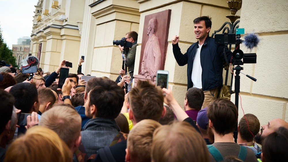 man in blue suit jacket standing near people