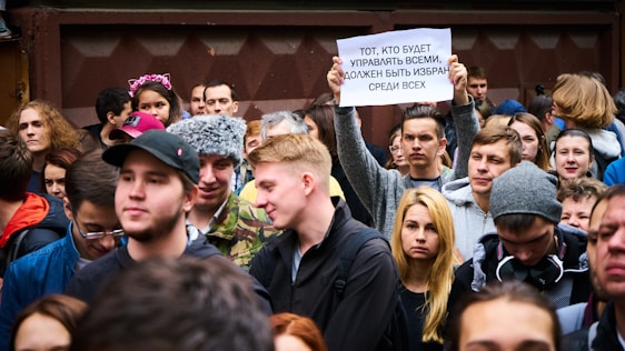 A diverse group of passionate people gathered in a bright banquet hall in Toronto, holding signs and sharing stories.