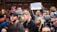 A group of diverse individuals collecting signatures at a community event.