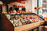 A vibrant display of seasonal fruits and vegetables outside the épicerie on a sunny day.