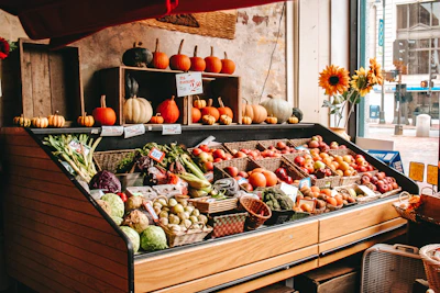 A vibrant display of seasonal fruits and vegetables outside the épicerie on a sunny day.