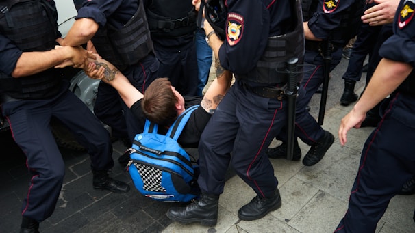 man in black jacket and black pants carrying blue and black backpack