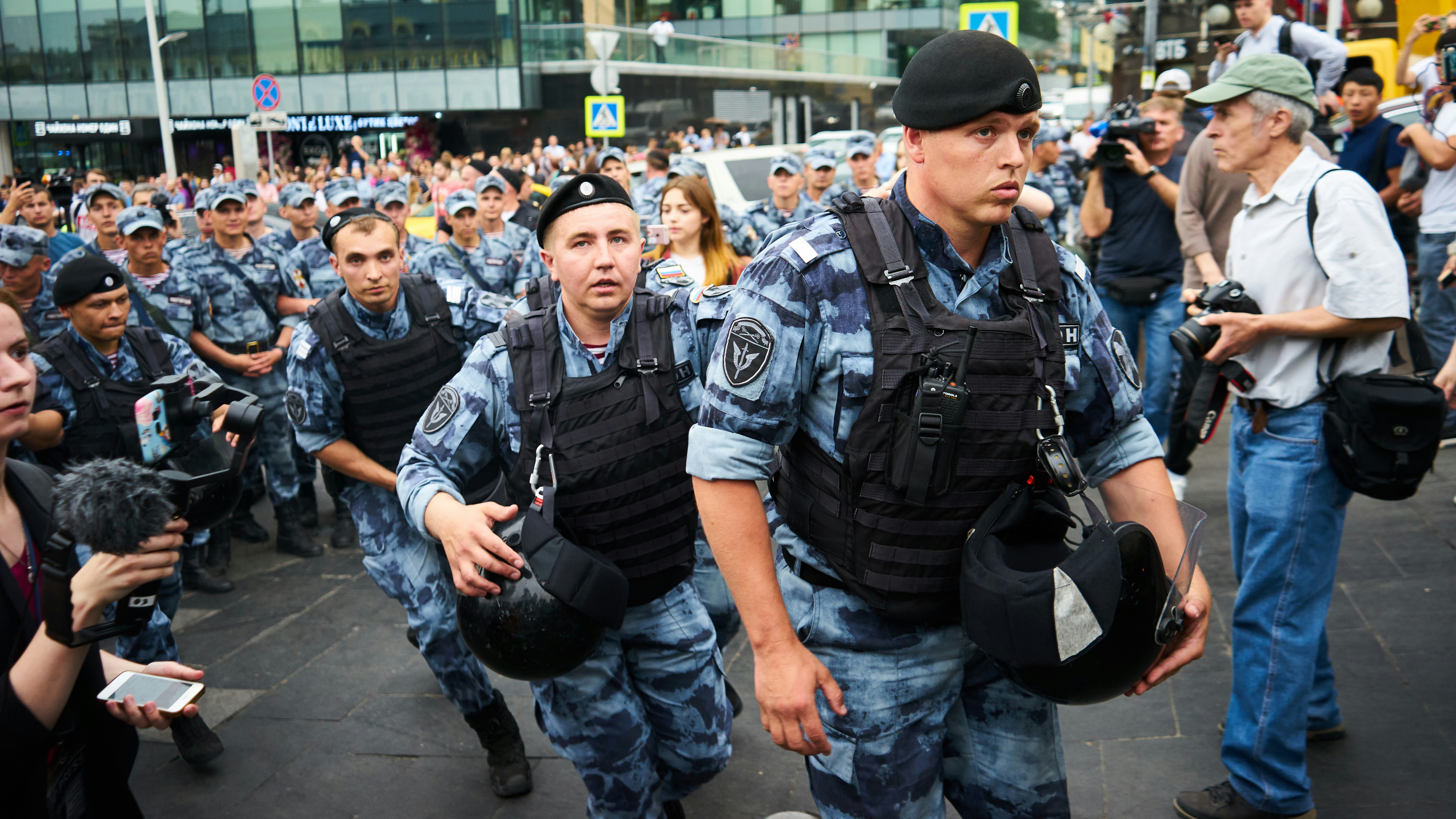 men in black police uniform standing on street during daytime