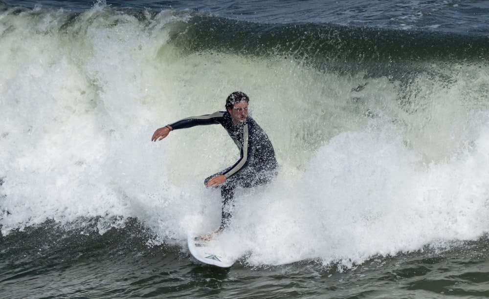 man surfing on sea waves during daytime