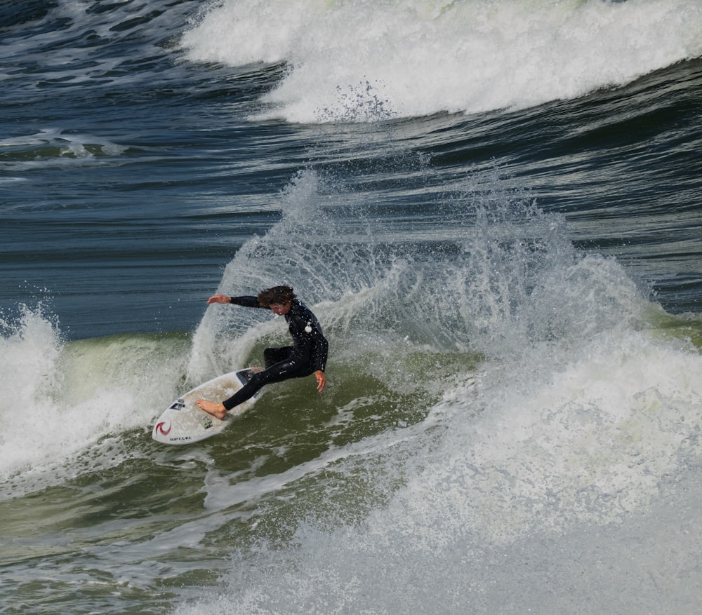 man surfing on sea waves during daytime