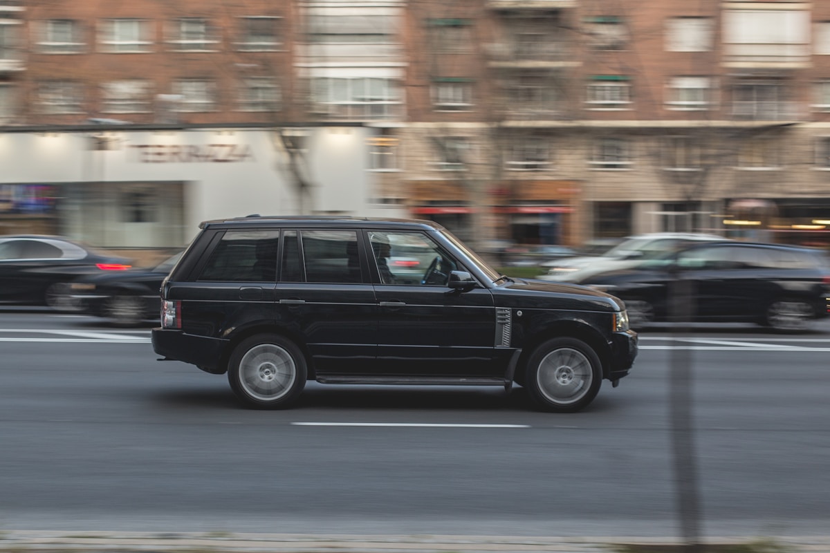 black luxury SUV on the road during daytime