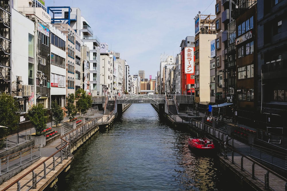 river between concrete buildings during daytime