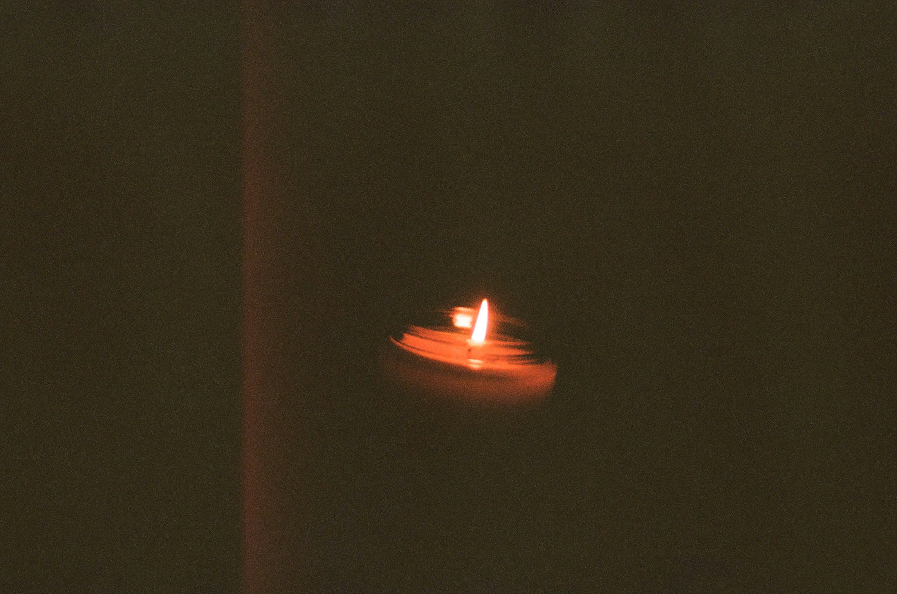 lighted candle in the dark