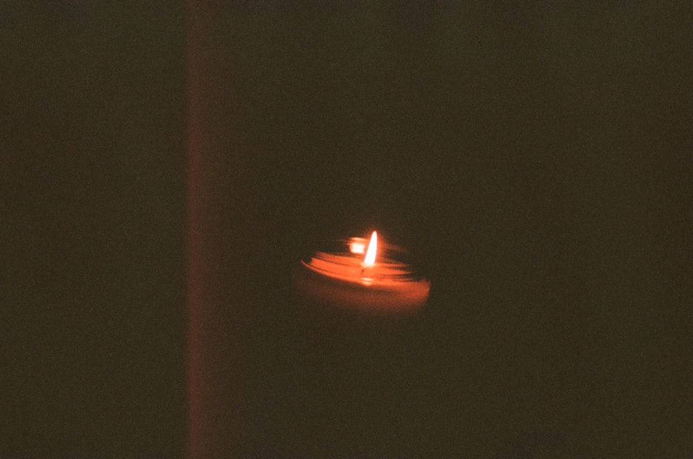 lighted candle in the dark