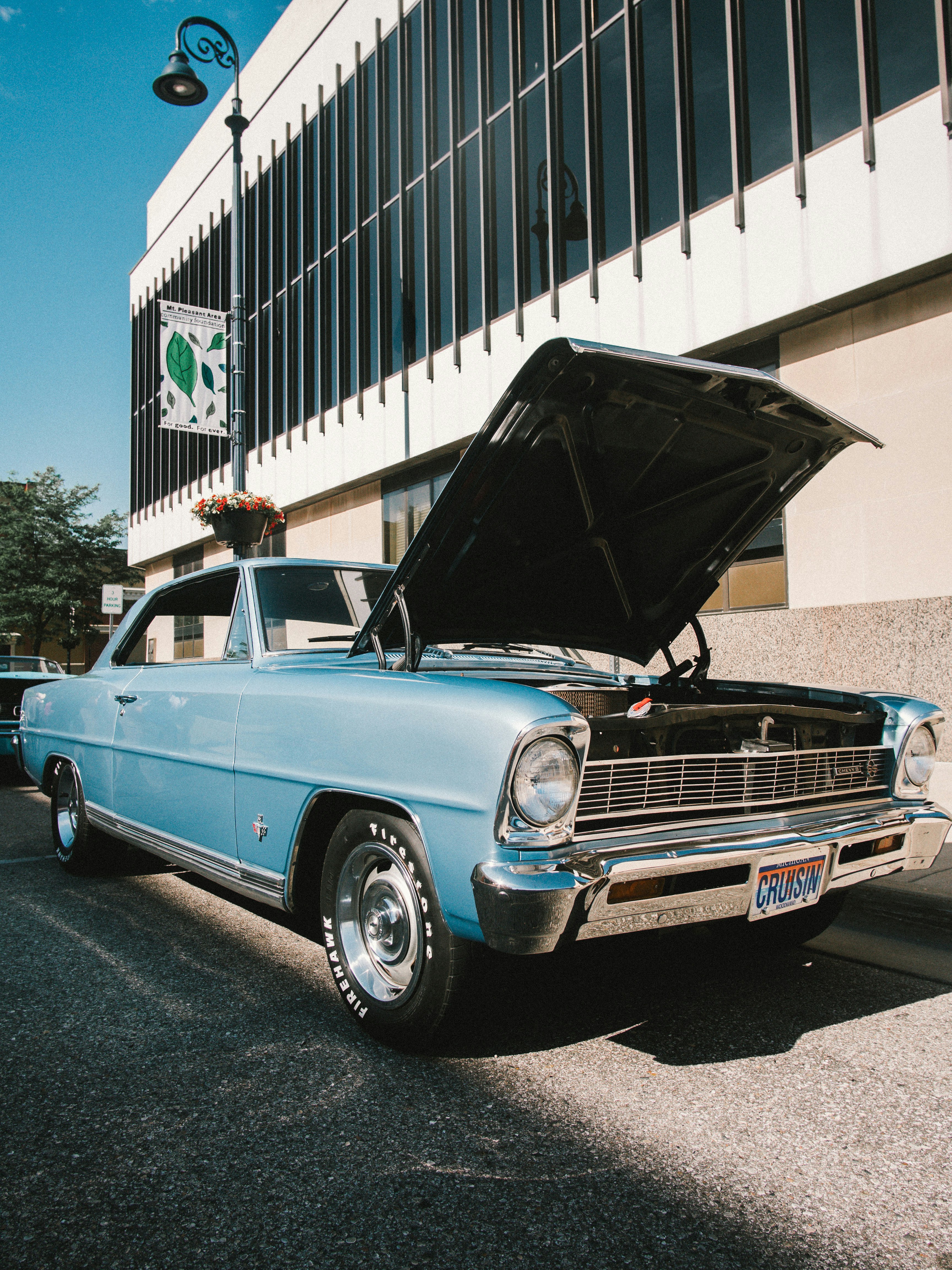 blue classic car parked near white building during daytime