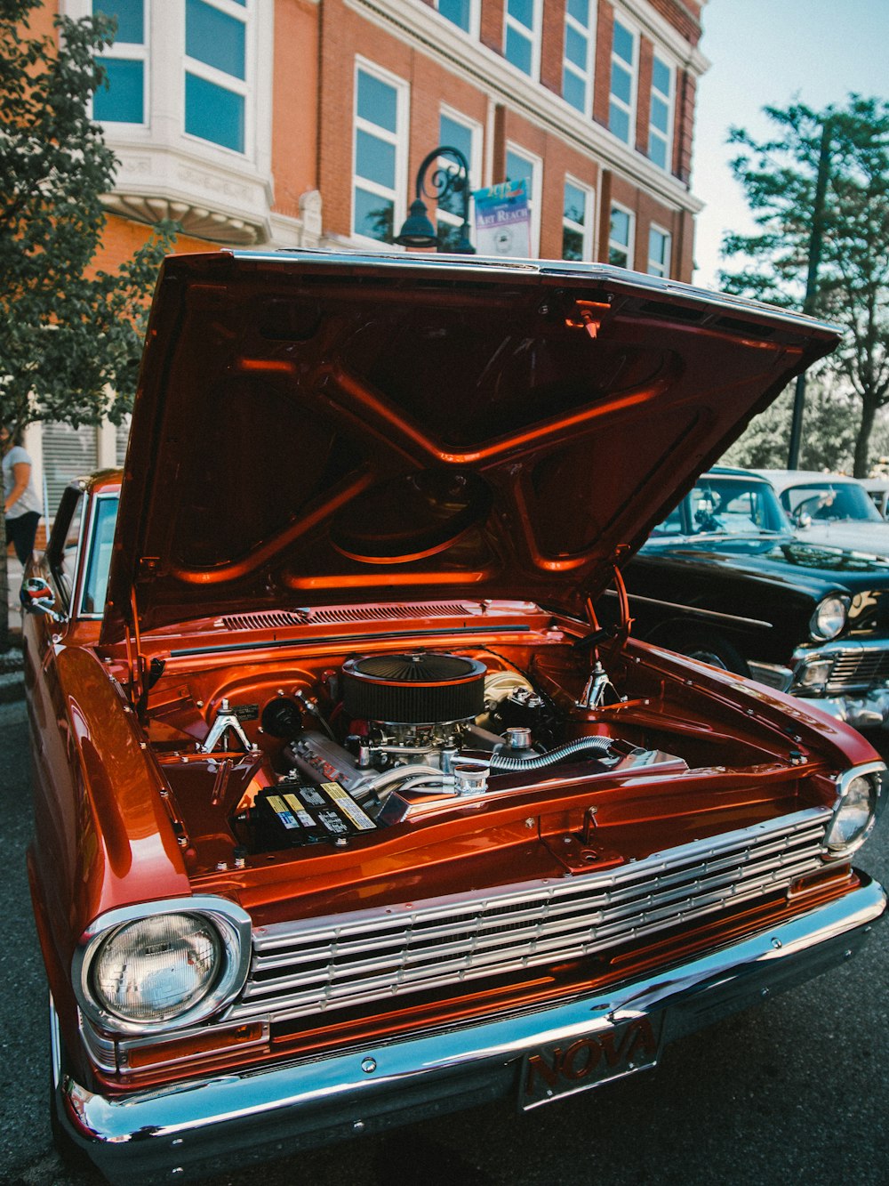 red and black car in front of white building