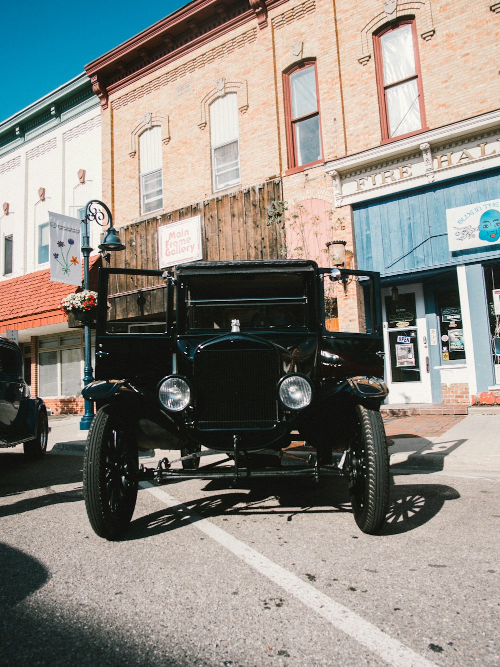 black vintage car parked beside brown concrete building during daytime