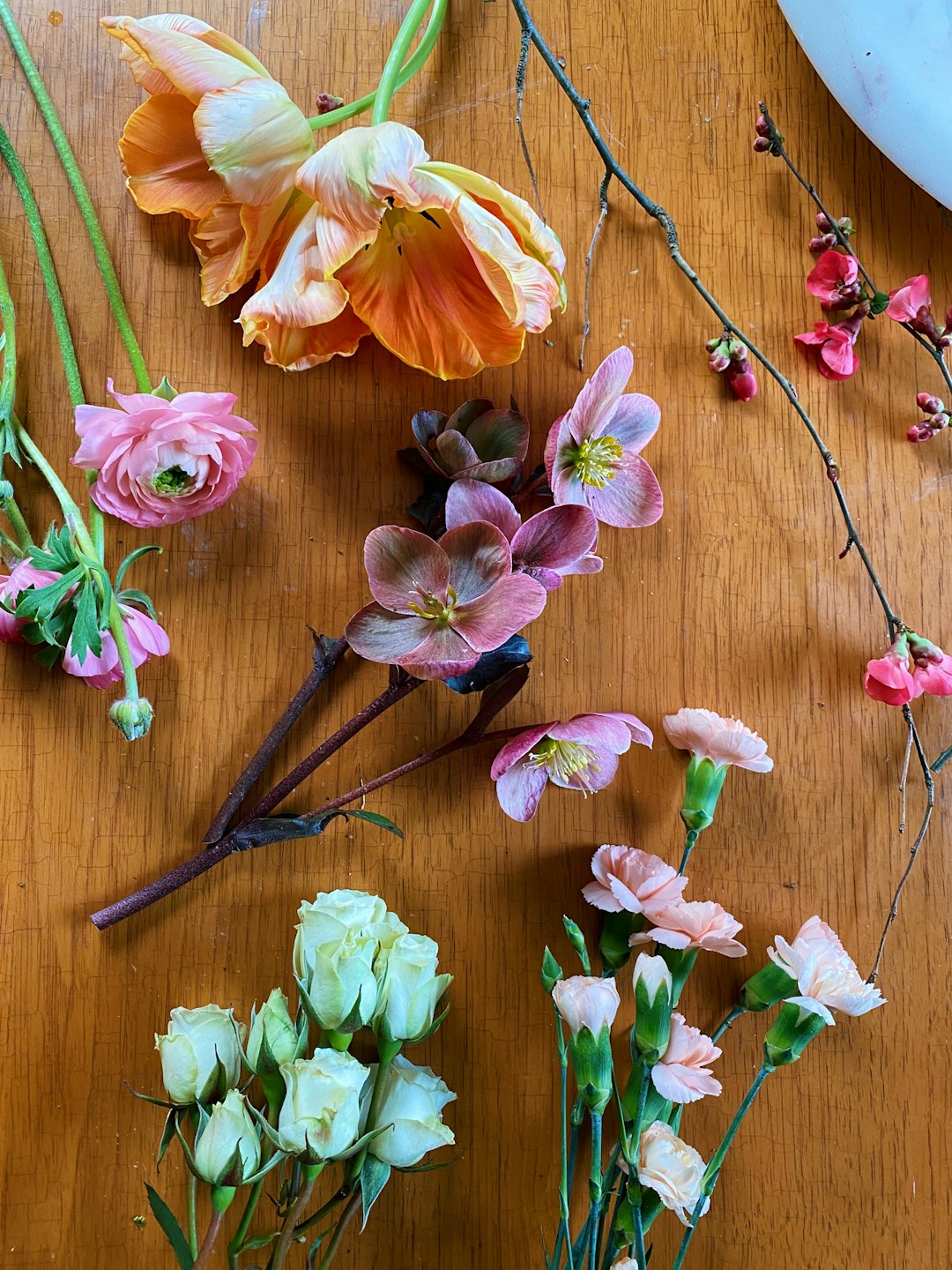 pink and yellow flowers on brown wooden surface