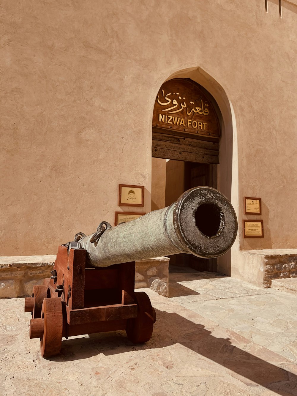 brown and black canon near brown concrete wall