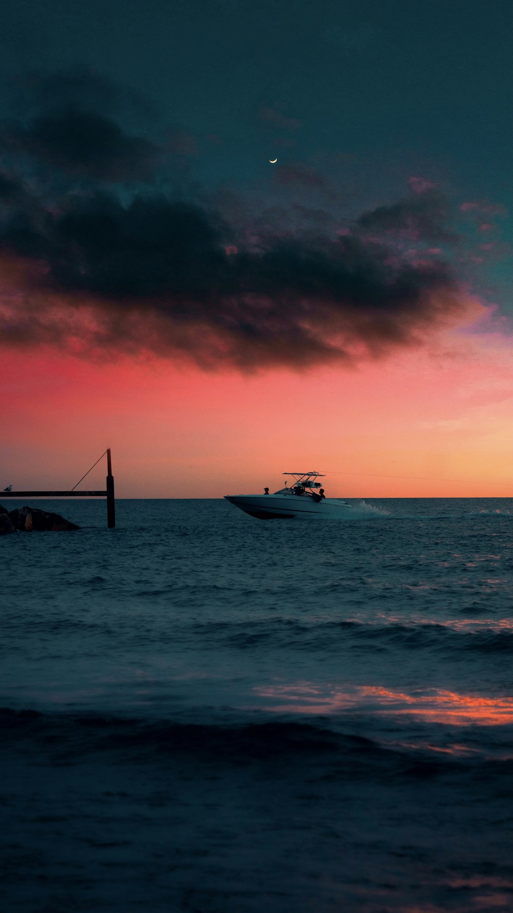 white boat on sea during sunset