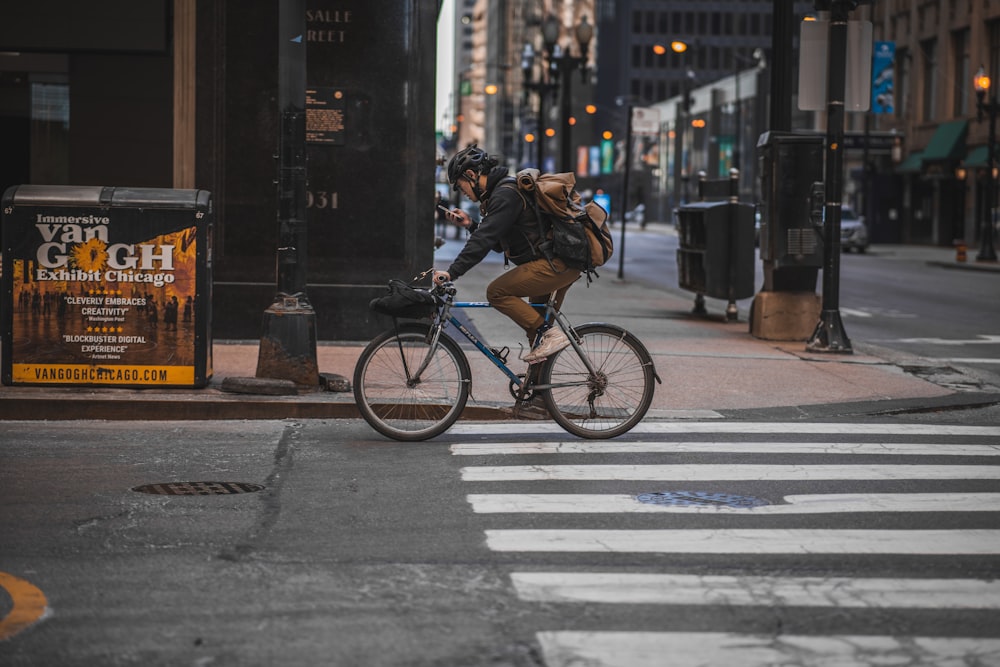 man in black jacket riding bicycle on road during daytime