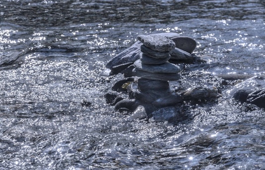 black stones on body of water during daytime