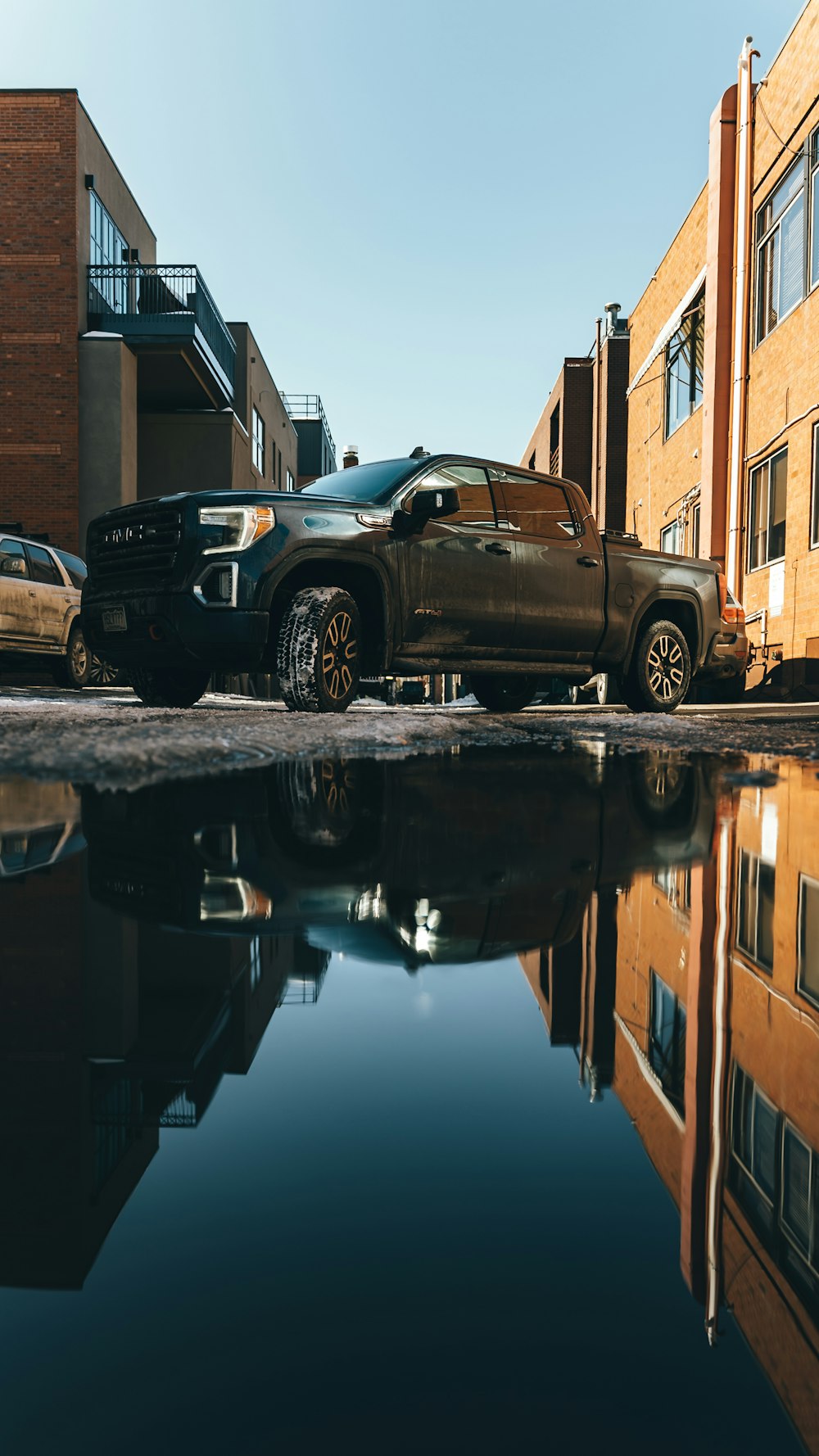 black chevrolet single cab pickup truck parked beside brown concrete building during daytime