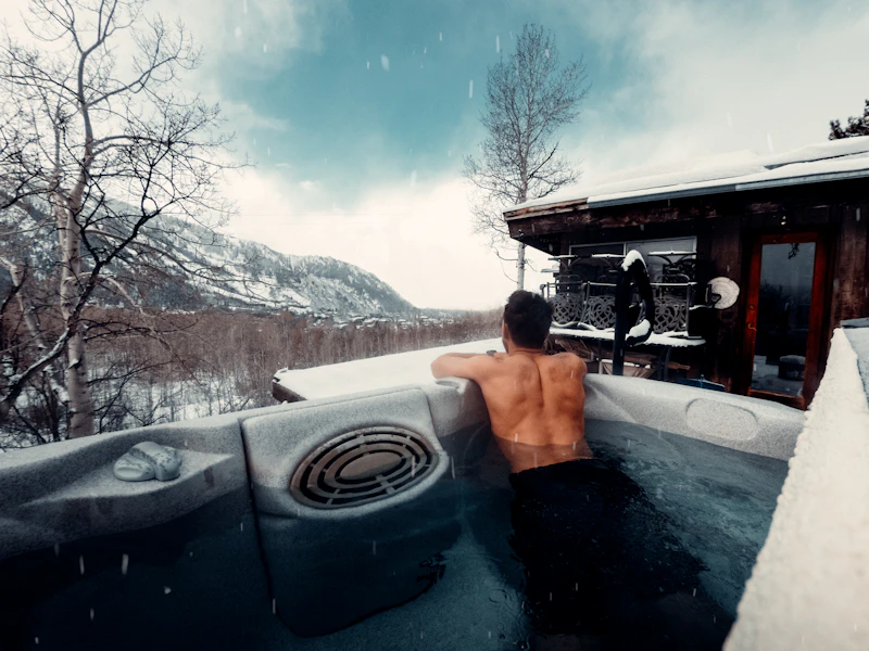 A warm pool ringed by snow and trees in the mountains — a winter wellness afternoon