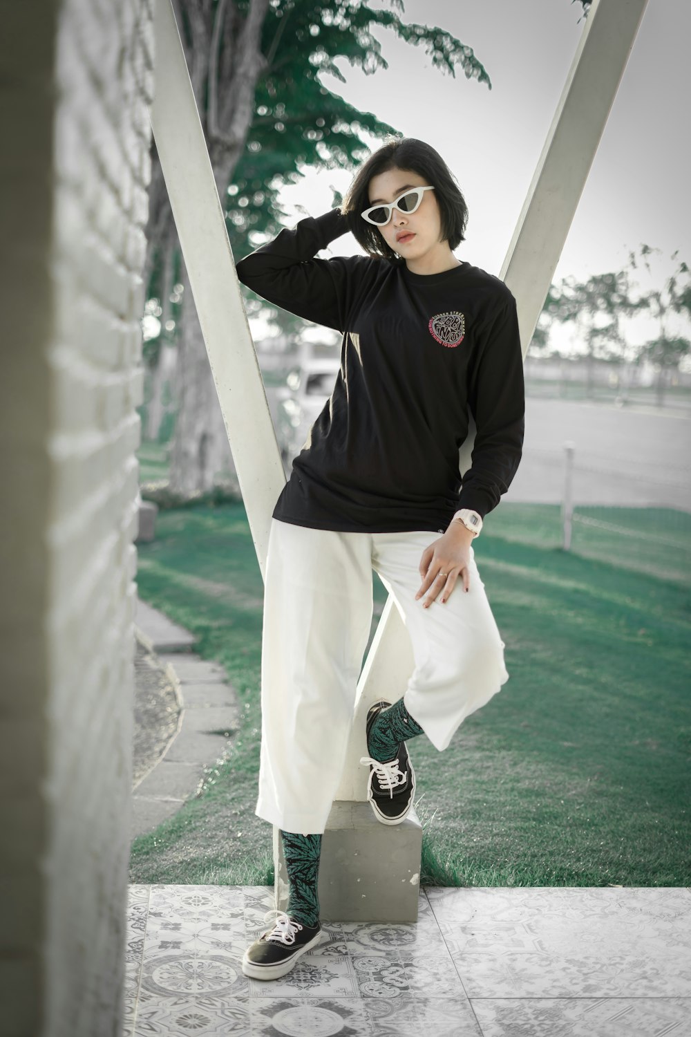 woman in black long sleeve shirt and white skirt standing on concrete floor during daytime