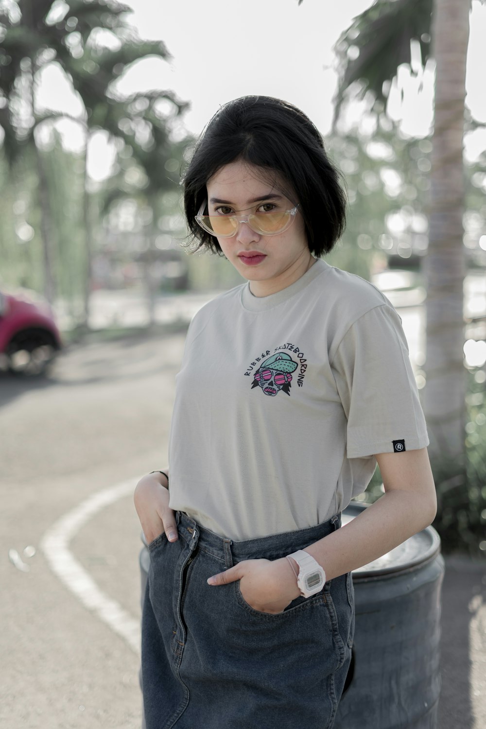 girl in white crew neck t-shirt and blue denim jeans sitting on concrete pavement during