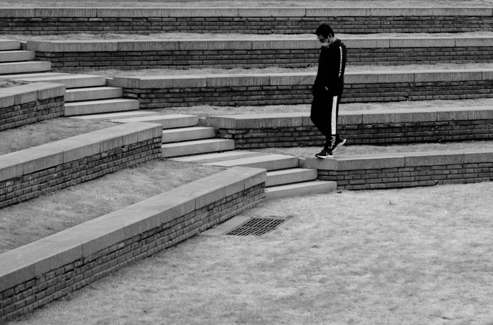 man in black jacket walking on gray concrete stairs
