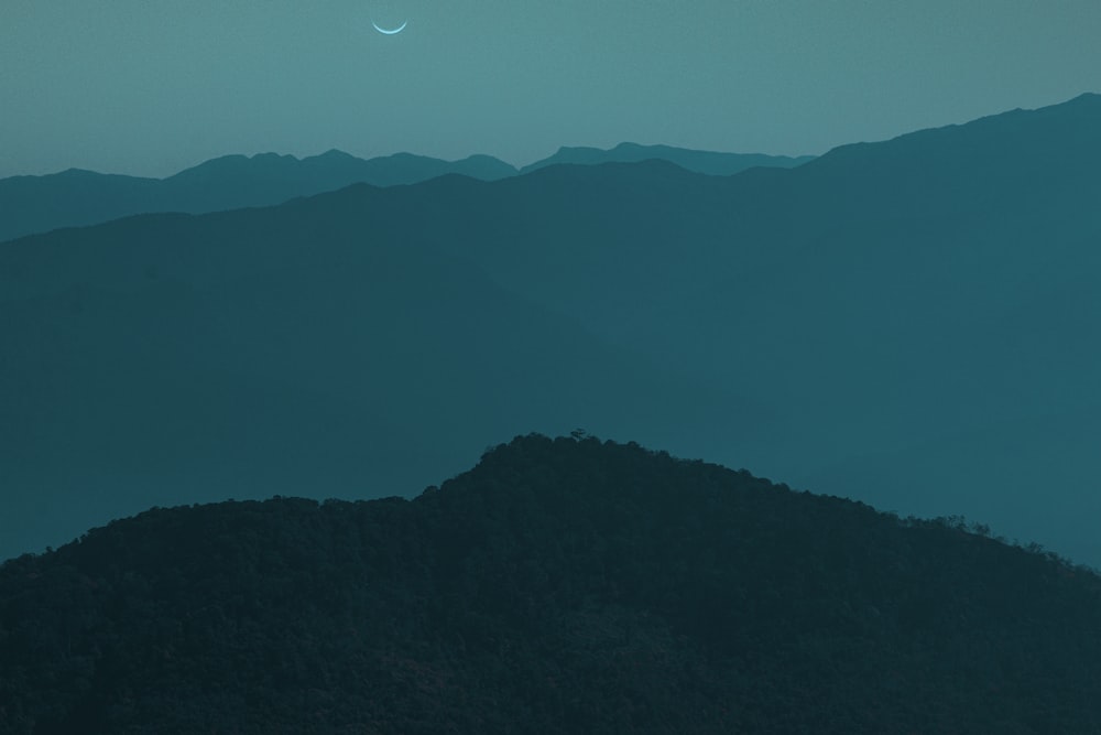 silhouette of mountain under blue sky during night time