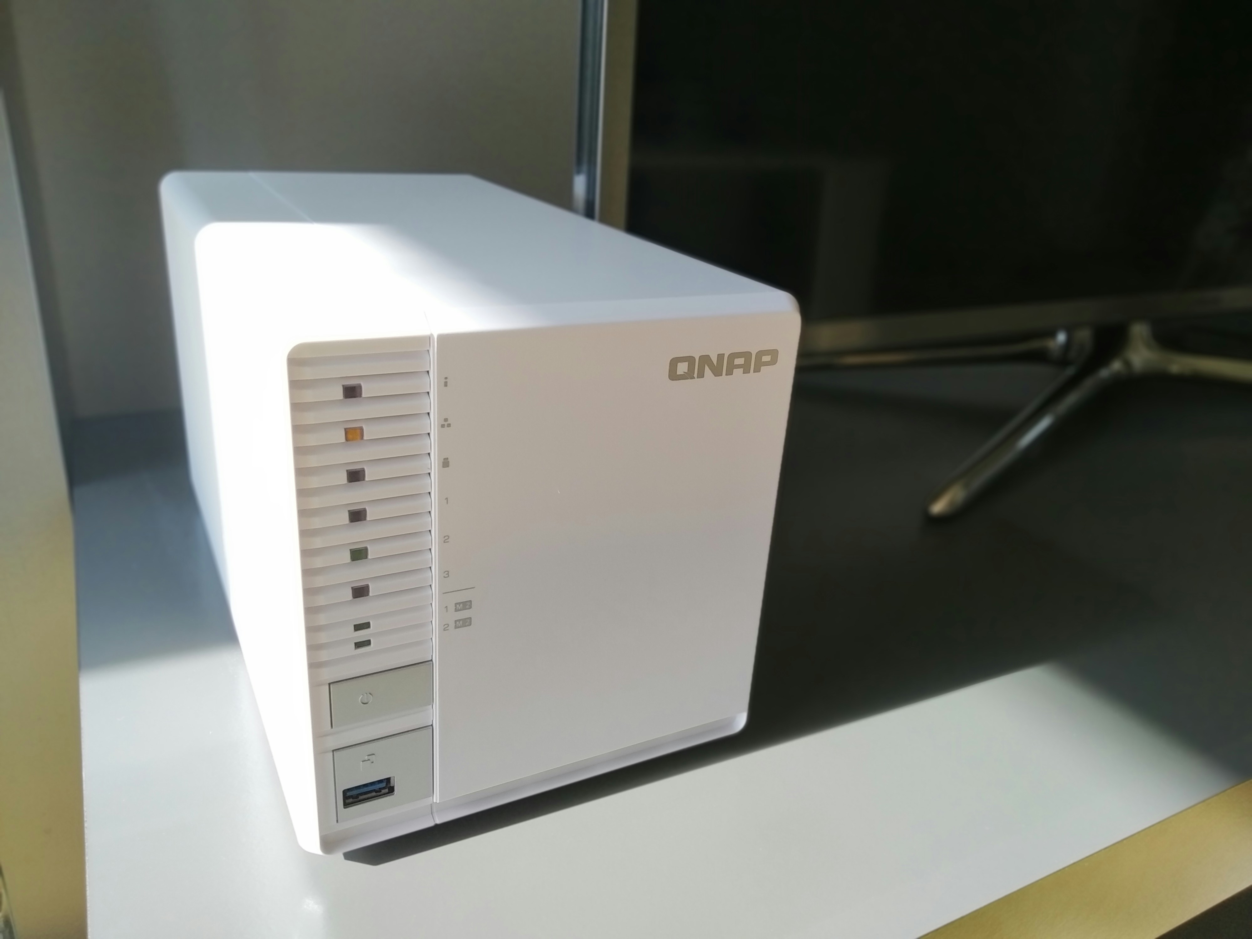 Network attached storage device on white shelf in home office, clean minimal setup