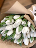 Elegant white lilies wrapped in natural brown paper ready for delivery