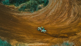 Wide view of an off-road track with natural obstacles and riders practicing.