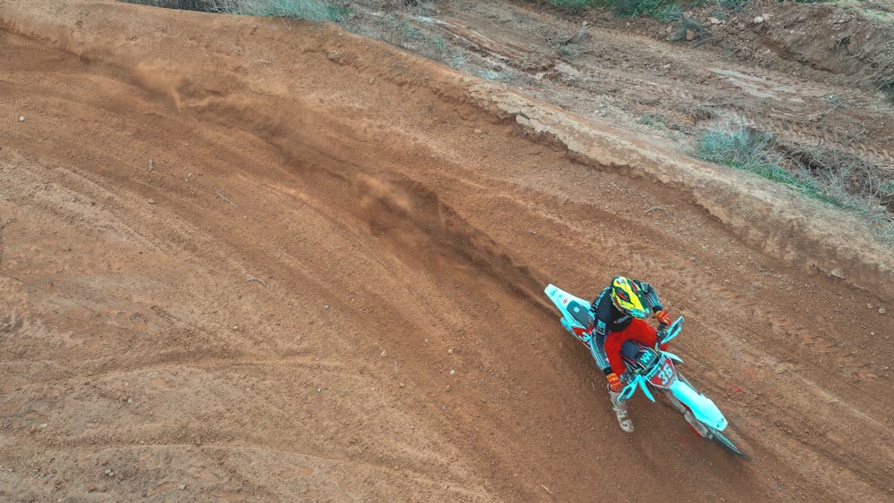 Mann fährt tagsüber Motocross-Dirtbike auf braunem Sand