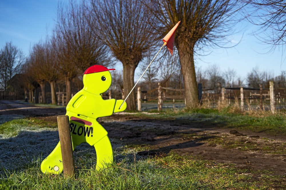 yellow and black cat statue on green grass field during daytime