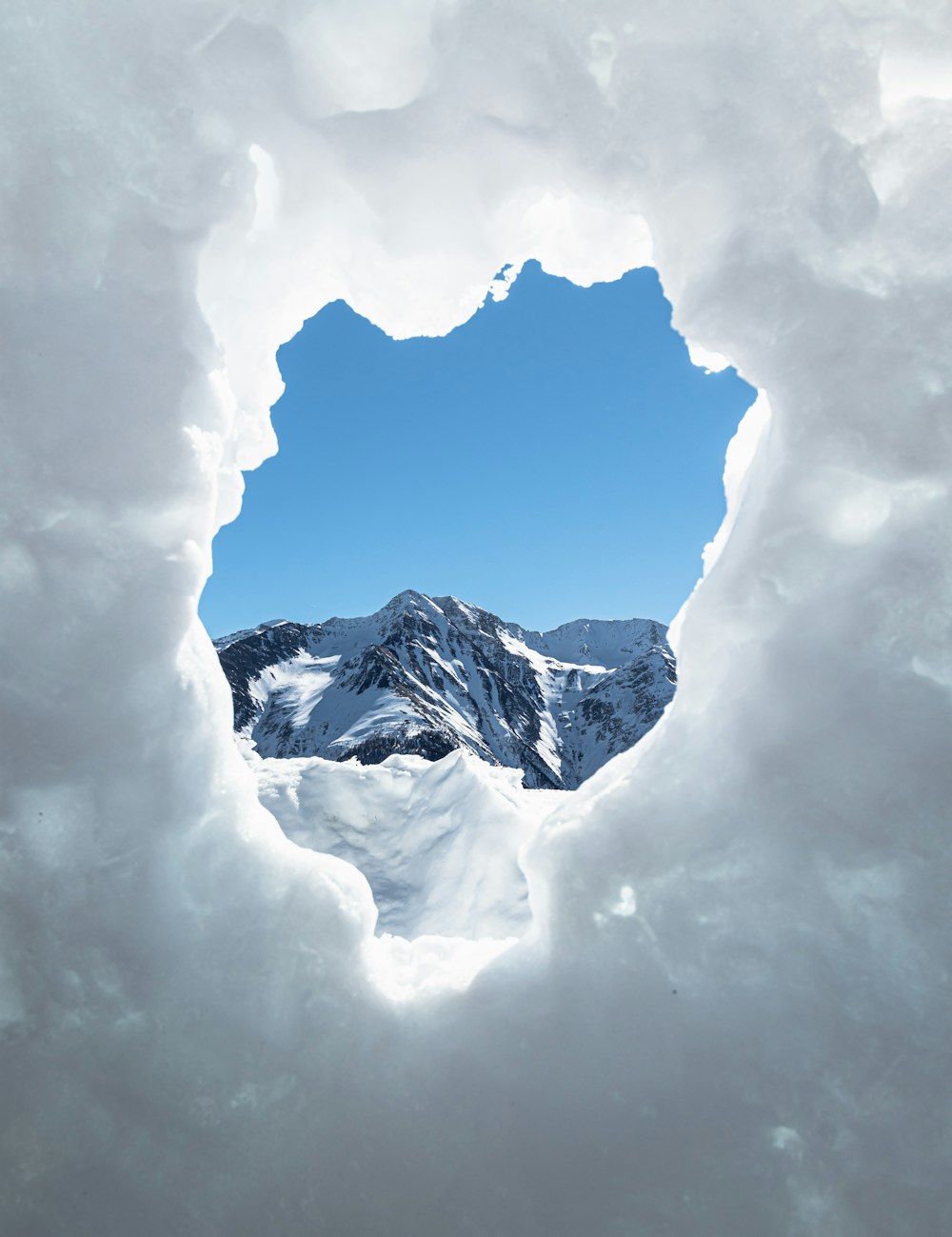 montagna innevata sotto nuvole bianche