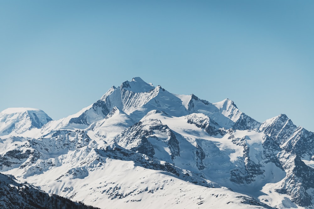 montanha coberta de neve sob o céu azul durante o dia