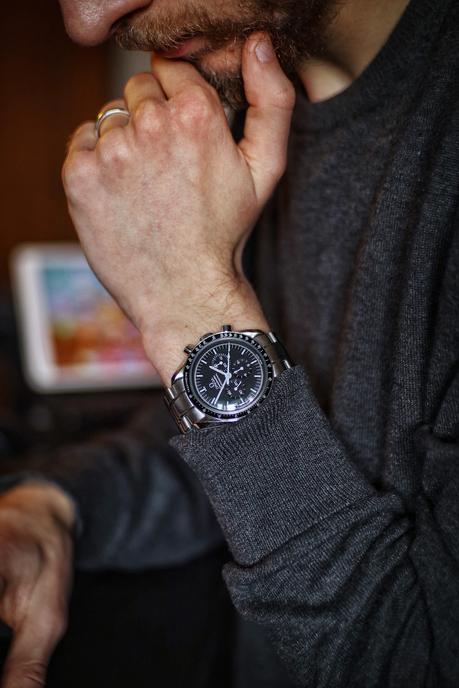 Omega Speedmaster on wrist, grey sweater