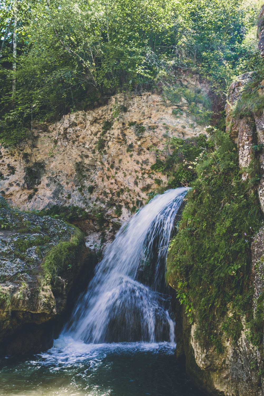 waterfalls in brown rocky mountain during daytime