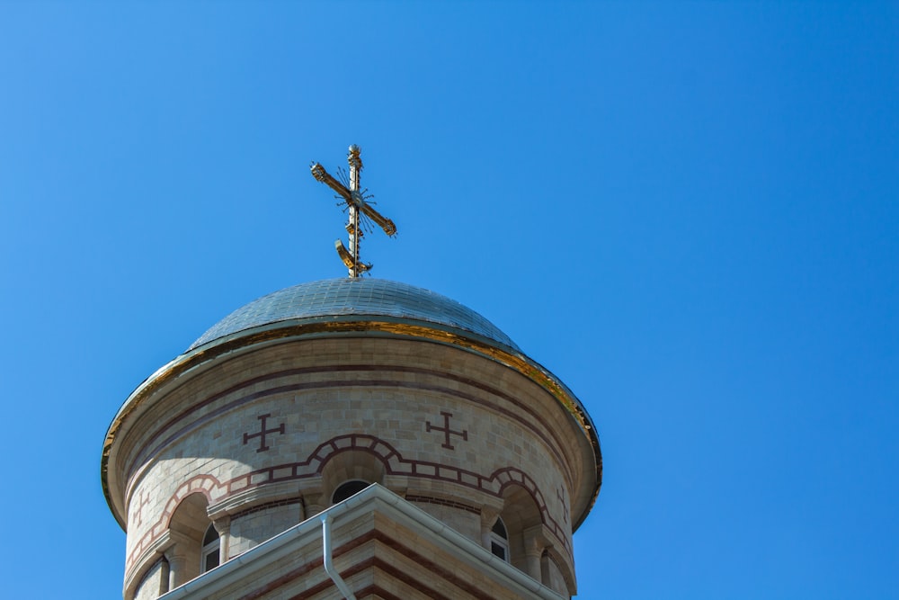 brown cross on top of white concrete building