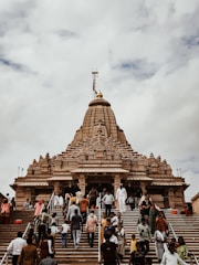 people walking on street near brown concrete building under white clouds during daytime