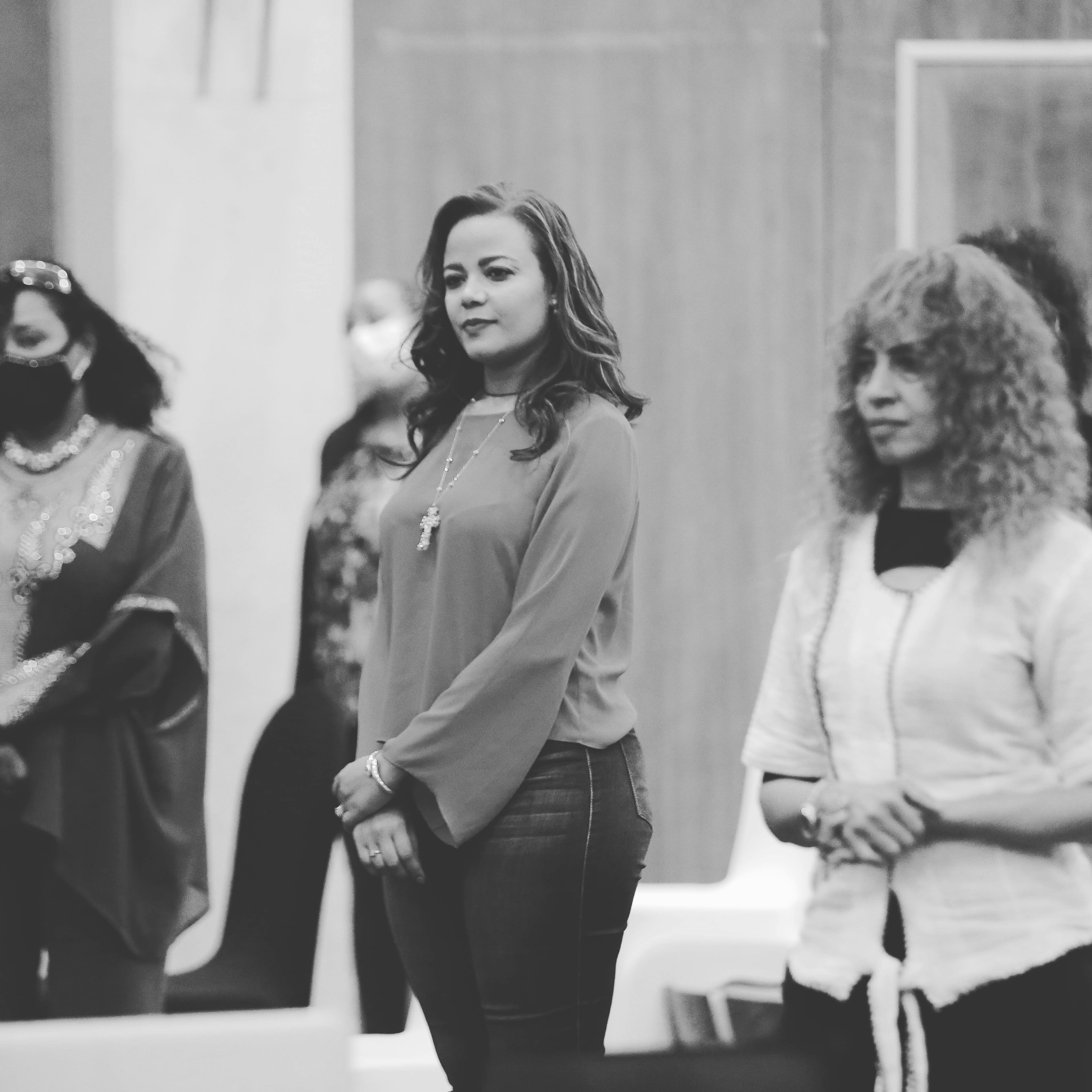woman in black dress standing beside woman in white long sleeve shirt