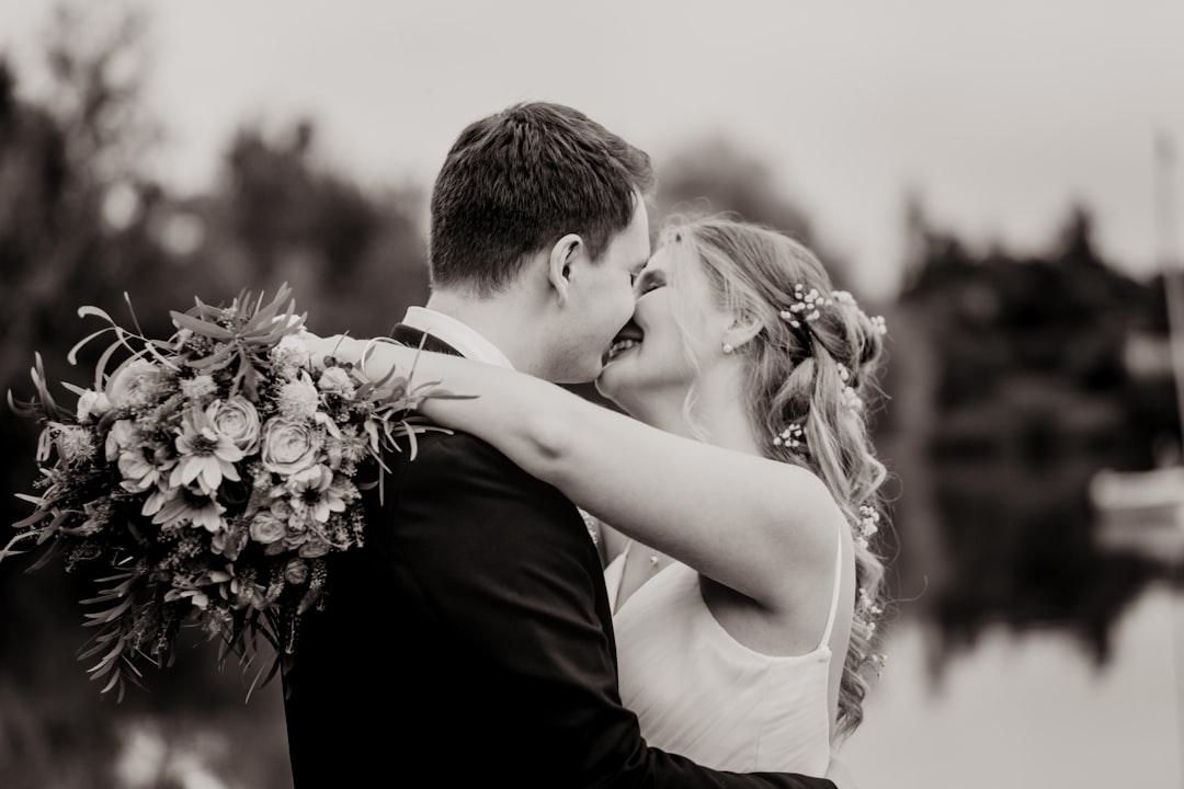 man and woman kissing in grayscale photography