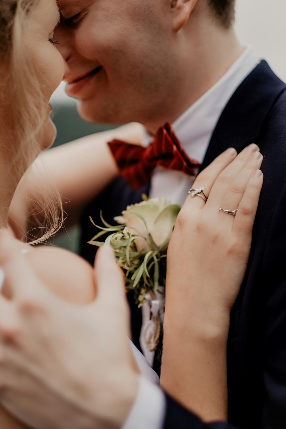 man in black suit jacket kissing woman in white dress