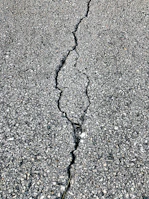 Close-up of a crack repair on an asphalt driveway, highlighting the quality patchwork.