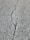 A close-up view of a cracked asphalt surface, showing a prominent crack running vertically through the rough, textured pavement.
