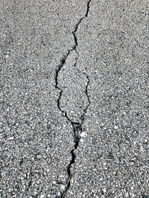 Close-up of a crack repair on an asphalt driveway, highlighting the quality patchwork.
