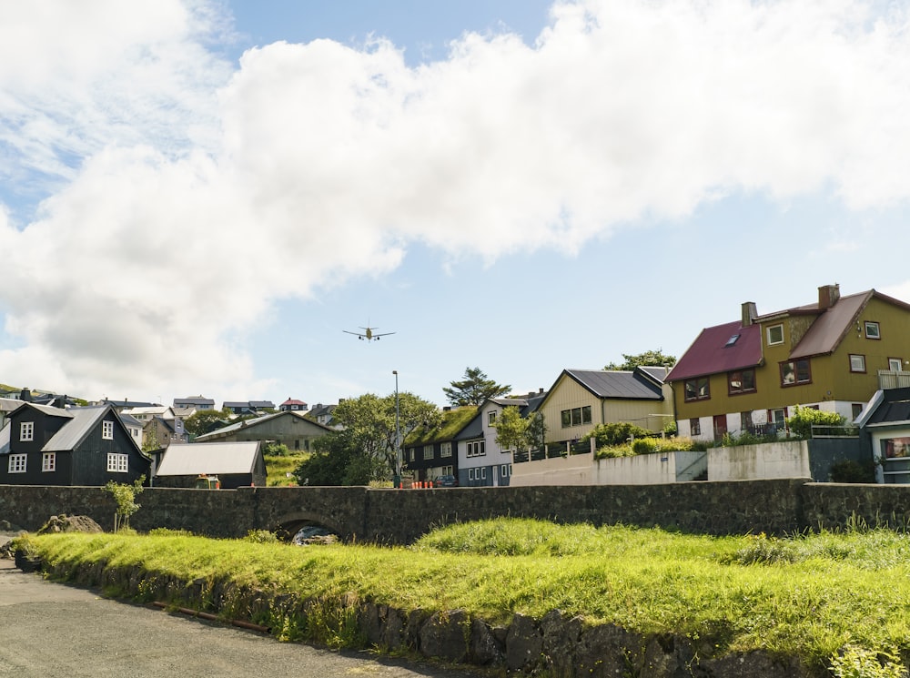 rot-weißes Betonhaus in der Nähe von grünem Grasfeld unter weißen Wolken tagsüber