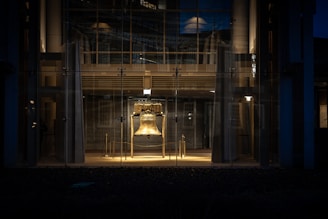 silver and gold bell on black steel fence